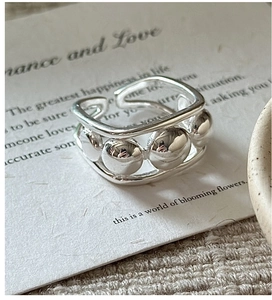 Macro view of adjustable S925 sterling silver ring with polished beads on poetic card