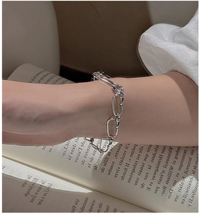 Détail d'un bracelet nœud rétro en argent S925 porté au poignet sur un livre français
