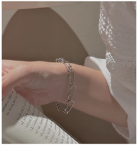 Détail du bracelet industriel en argent S925 avec design noué posé sur un magazine français