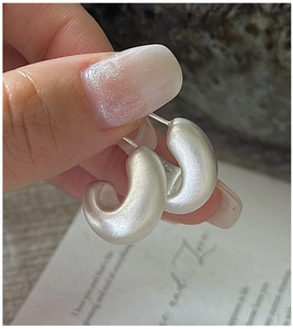 Close-up of S925 sterling silver C-shaped hoop earrings with a matte frosted finish