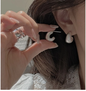 Detail of S925 sterling silver C-shape earrings featuring a matte brushed metal finish