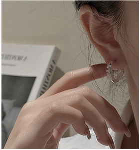 Close-up of S925 sterling silver woven hoop earring on model for minimalist style