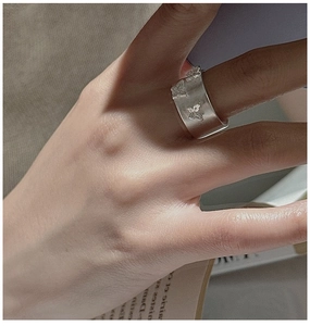 Gros plan d'une bague large en argent 925 mat avec gravures détaillées de papillons