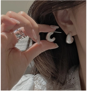 Detailed macro view of S925 sterling silver earrings with matte brushed metal texture