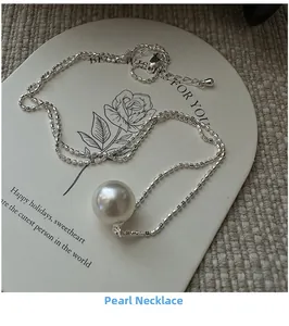 Detailed view of single white pearl necklace with silver chain on floral display card