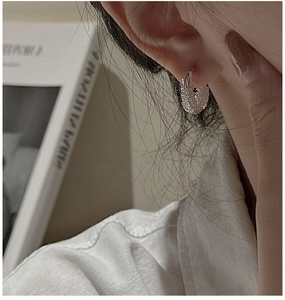 Close-up of S925 silver hoop earrings with a unique textured lava design on a model