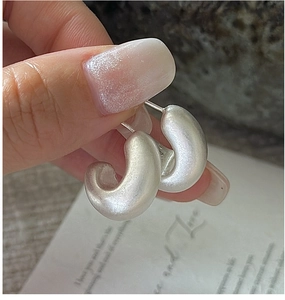 Detailed view of S925 sterling silver C-shaped earrings with a matte frosted finish