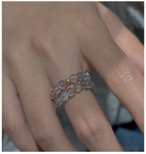 Detail view of double-layered gray moonstone beads ring with a golden metallic accent bead