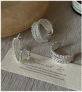Close-up of retro S925 sterling silver beaded twisted earrings with woven texture details