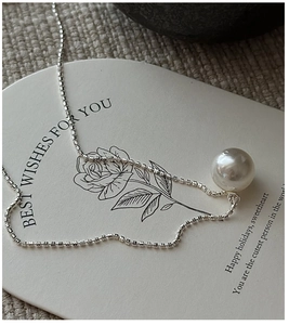 Detailed macro view of S925 sterling silver chain with a large lustrous white pearl pendant