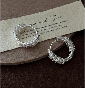 Close-up of S925 sterling silver hoop earrings with intricate woven texture detail