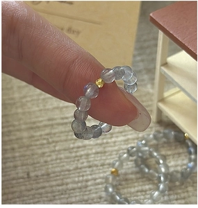Macro shot of grey moonstone beaded ring with a faceted gold bead on a minimalist band