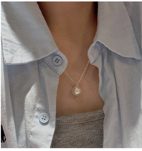 Close-up of S925 sterling silver necklace with a round white pearl pendant on a neck