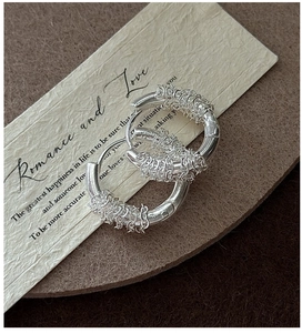 Detailed close-up of S925 sterling silver woven hoops with intricate chain-wrapped texture