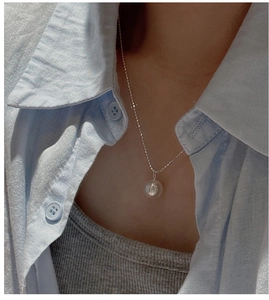 Minimalist S925 silver necklace with white pearl pendant worn on a blue linen shirt