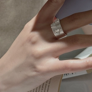 Bague papillon minimaliste en argent mat avec relief vintage portée au doigt