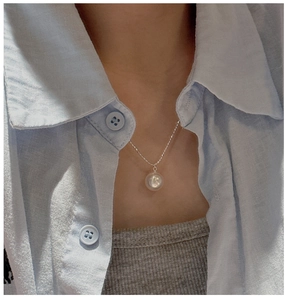 Macro shot of minimalist S925 sterling silver necklace featuring a large round shell pearl