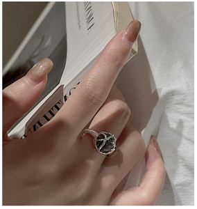Primer plano detallado de un anillo de plata con obsidiana negra puesto en el dedo