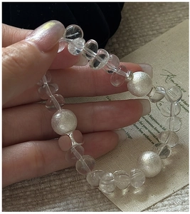 Detailed view of S925 silver beaded bracelet with clear white crystal on a hand