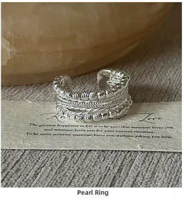 Detailed view of S925 sterling silver beaded rings with textured layers on display card