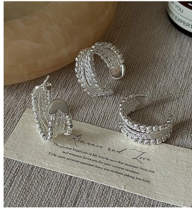Detailed view of S925 sterling silver beaded C-shape earrings on a linen surface