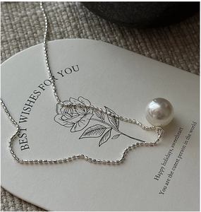 Detailed macro view of S925 sterling silver chain and lustrous white pearl pendant