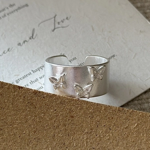 Bague ouverte large en argent mat ornée de trois papillons gravés en relief