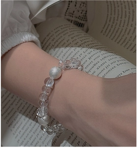 Detail of S925 silver beaded bracelet with clear crystals on a minimalist book background