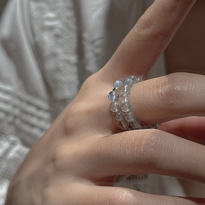 Hand wearing minimalist S925 silver double-row grey moonstone beaded ring with gold accents