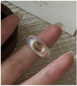 Makroaufnahme von Silberring mit Rutilquarz und strukturierter Ringbandschiene