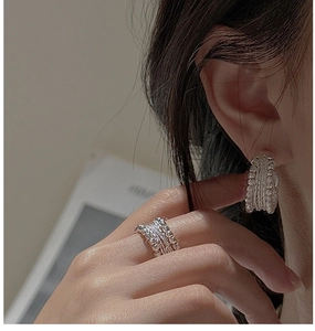 Macro detail of S925 sterling silver handmade beaded texture on rings and earrings