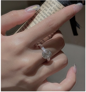 Detail of S925 silver rope ring with oval clear stone on vintage poetic paper background