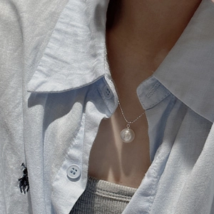 Elegant S925 sterling silver necklace featuring a large white shell pearl pendant on a model
