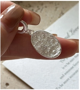 Detailed macro view of S925 sterling silver oval daisy pendant with small crystal stone