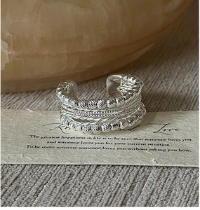 Detailed close-up of S925 sterling silver beaded and twisted ring on decorative card