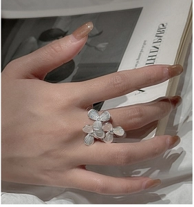 Macro detail of S925 sterling silver flower ring with matte texture and small diamonds
