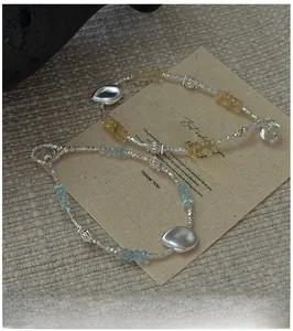 Detail of S925 silver beaded bracelets with light blue and yellow faceted gemstones