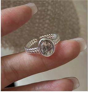 Detailed shot of an S925 silver ring with an oval black rutilated quartz and rope band