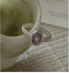 Macro shot of S925 silver braided ring with oval black rutilated quartz in bezel setting
