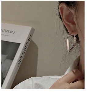 Close-up of minimalist S925 sterling silver square hoop earring worn by model