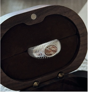 Makroaufnahme von S925 Silberring mit Rutilquarz in einer dunklen Holz-Schmuckschatulle