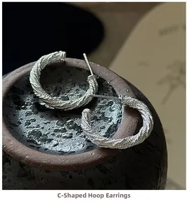 Détail macro de boucles d'oreilles créoles torsadées en argent S925 avec texture vintage