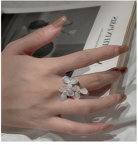 Detailed macro view of S925 silver flower ring with matte texture and small white stones