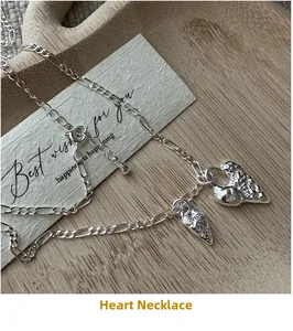 Detailed macro view of S925 silver heart necklace with lava texture on a wooden tray