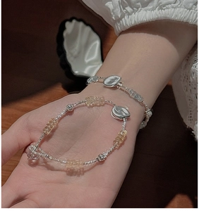 Detail of S925 silver beaded bracelet with citrine stone on a wrist and hand