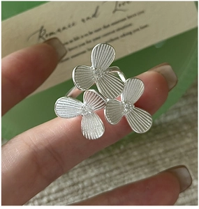 Detailed view of S925 silver ring featuring three heart-petal flowers with brushed finish