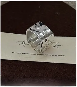 Detail of wide S925 sterling silver ring featuring handmade hammered lava texture