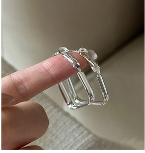 Close-up of S925 sterling silver rectangular hoop earrings with polished finish on hand