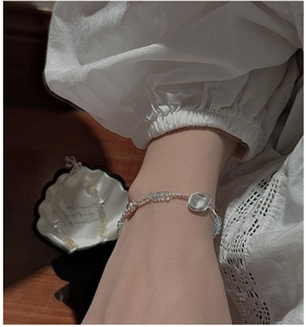 Detail of beaded S925 silver bracelet with light blue gemstones on a female wrist