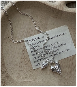 Macro view of S925 sterling silver layered heart pendant with liquid metal texture